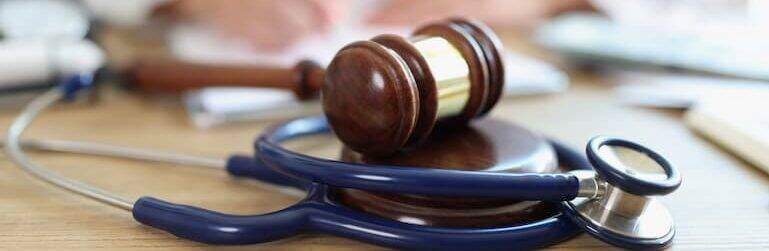 Stethoscope and gavel on desk, symbolizing healthcare and justice.