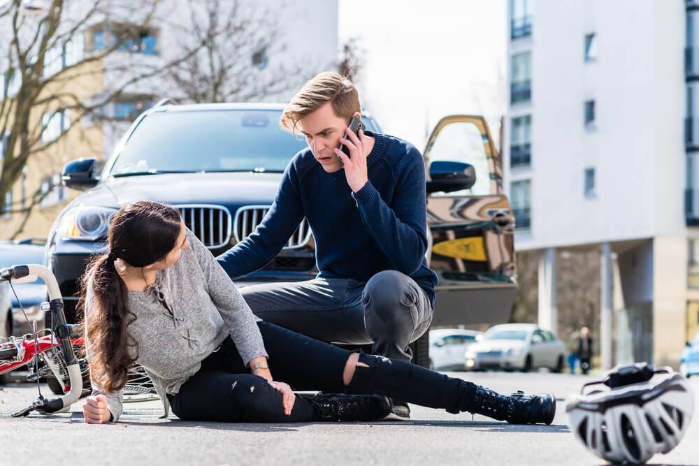 Injured cyclist being helped after accident – Bicycle Accident Attorney in Greensboro can help you seek compensation.