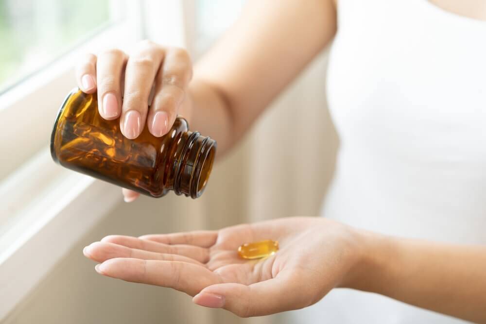 Person taking supplement from pill bottle – possible case for product liability attorneys in Greensboro NC